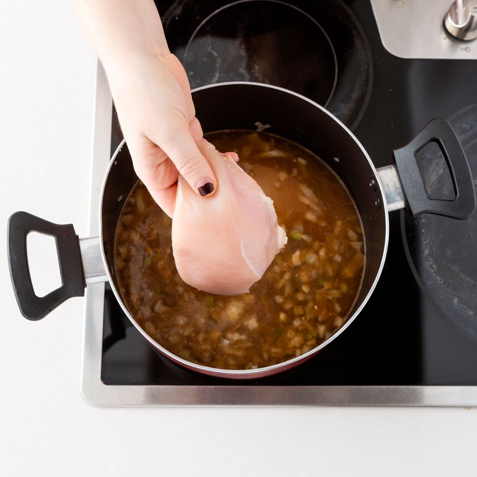 Add in your chicken breast. Once your broth reaches a boil, reduce the heat to medium and cover the pot. Cook the chicken through by gently boiling it for about 15 minutes.