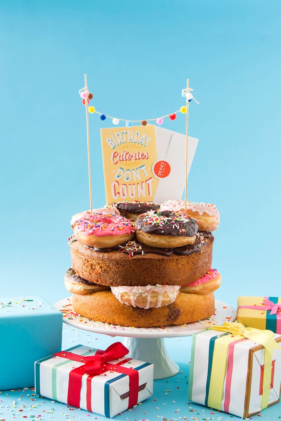 Let the cake cool. Place one of the bundt cakes on a cake stand. Place donuts all over the cake layer. Add another bundt cake on the donuts. Frost that layer with frosting and add more donuts.