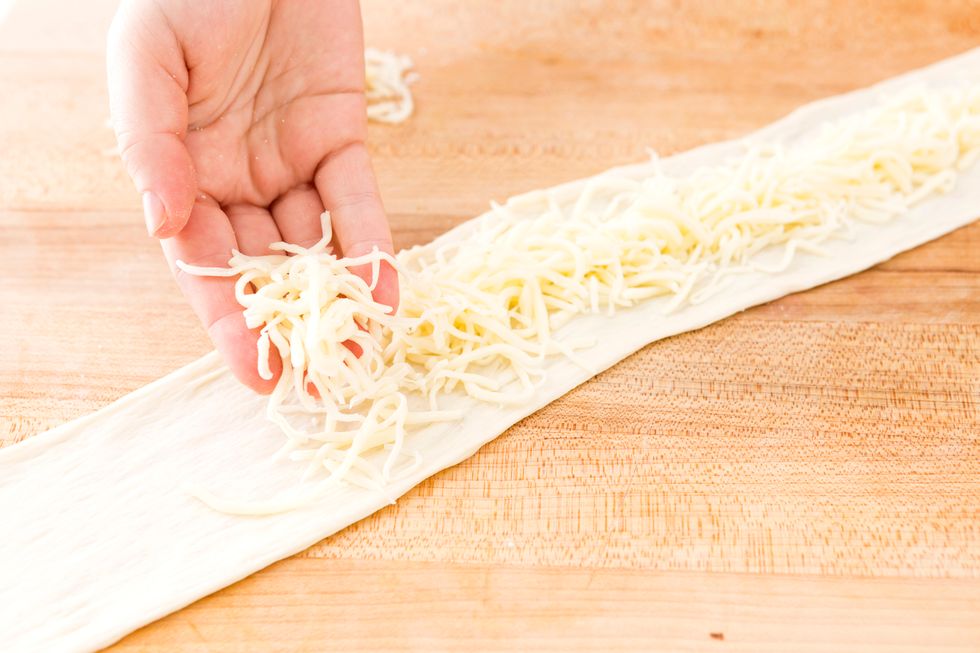 Stretch each to be about three inches wide and about 34 inches long each. Sprinkle 1 cup of cheese in the center of each strip.