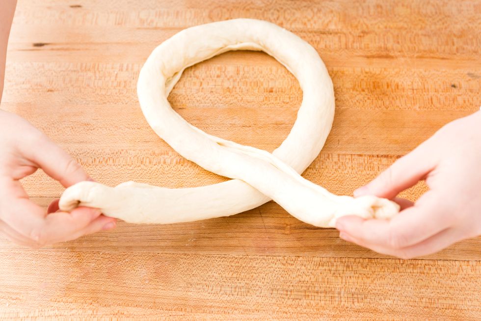 To make your pretzels, take one of your dough logs, and form a circle.