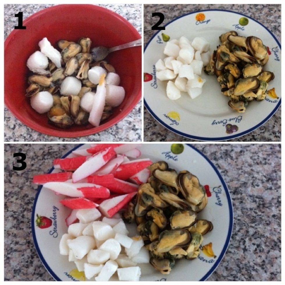 1) After 10min or so the seafood has been defrosted, throw water away and squeeze absorbed water from seafood with your hand; 2) 'Dry' \ue405; 3) Set aside with the surimi sticks