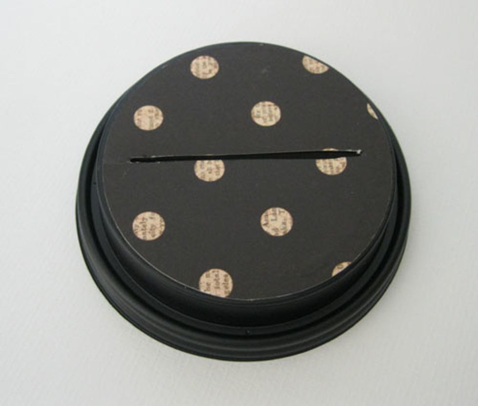 12.\tCut out a 2 7/8\u201d circle of decorative paper.  Glue to the cup lid.  Cut slit into paper.