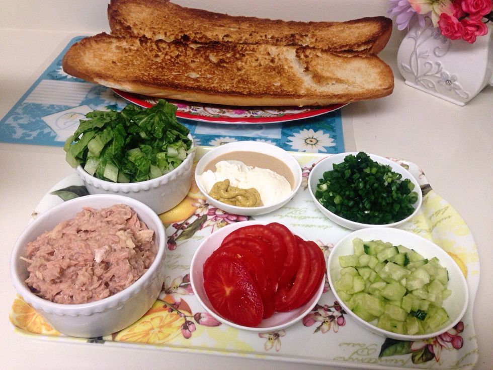 2 cups tuna 1cup romaine lettuce (shredded) 1 Italian / French bread 1/2 cup chopped cucumbers 1/2 cup green onions / chopped 1tbsp tahini sauce, 1tbsp cream cheese, 1tbsp mayo, 1tbsp dijon mustard
