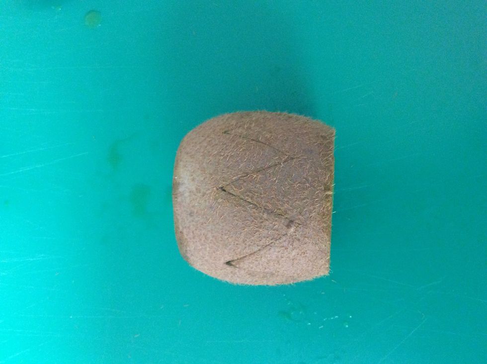 2. Cut diagonal cuts into center of kiwi creating triangle shapes (approximately 2 cm)