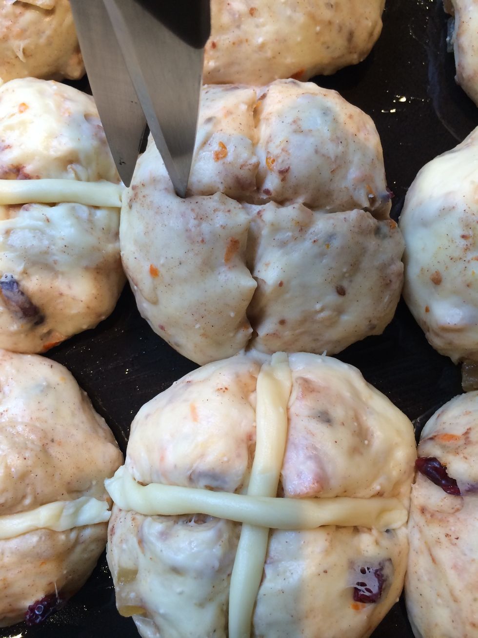 2 hrs after the buns are tripled in size....time to put the crosses. Snip delicately the surface of each bun with the scissors without disturbing the dough. And place the ropes of dough in a cross