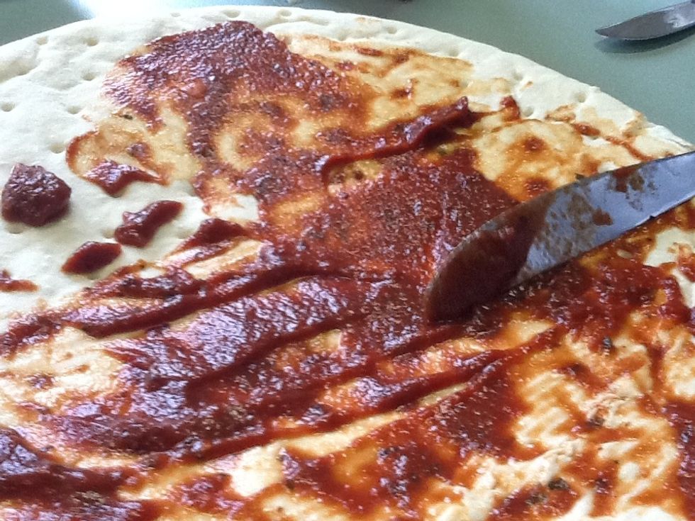 (2)Spread the sauce on the pizza base.