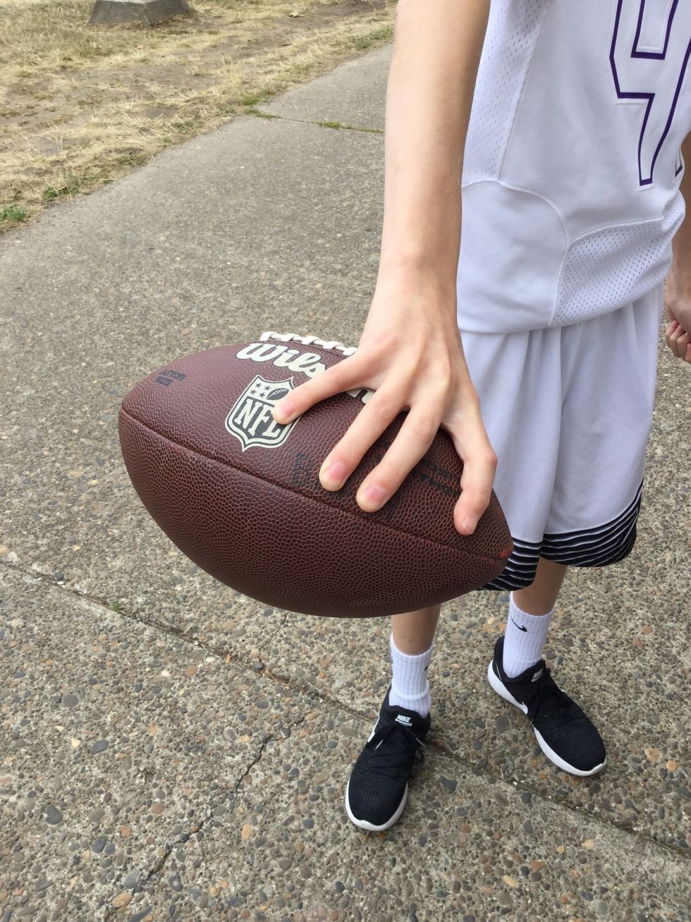 3. Have one person hold the football in there dominant hand with your fingers on the laces.