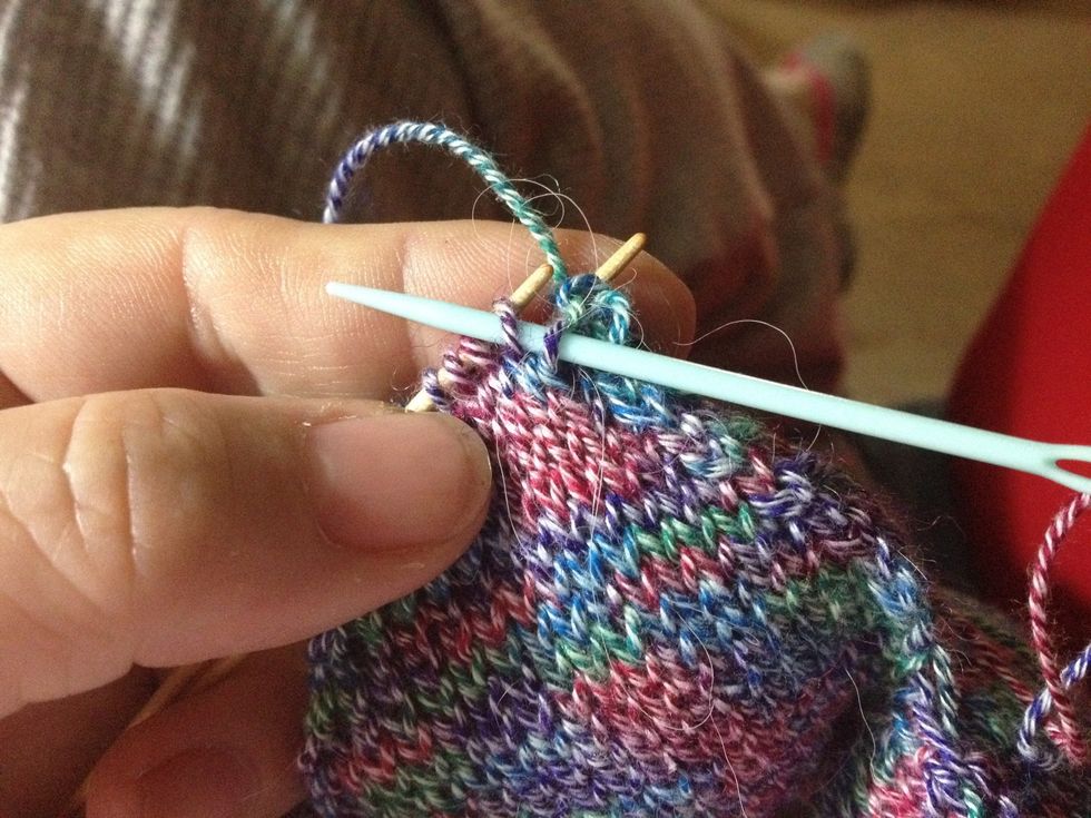 3) Insert the tapestry needle purlwise in the now 1st stitch on the front knitting needle. As you pull the yarn you'll be coming through two stitches at once.
