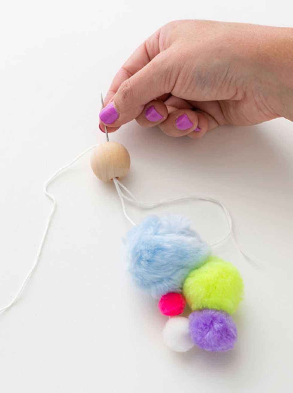 3. Take both ends of your embroidery thread and string them through the wood bead.