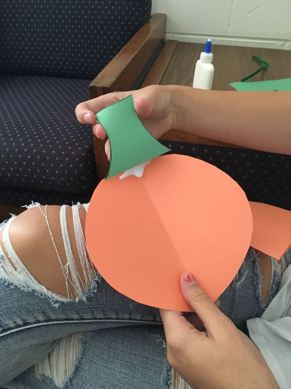 3. Then, glue the stem to the top of the pumpkin shape.