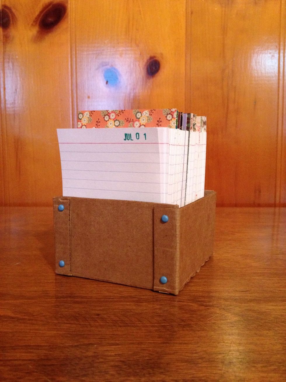 365 index cards plus dividers is about 3.25" deep, too, so the container must accommodate all cards for the year. I made this cardboard holder from scrap cardboard and brads to hold it together.