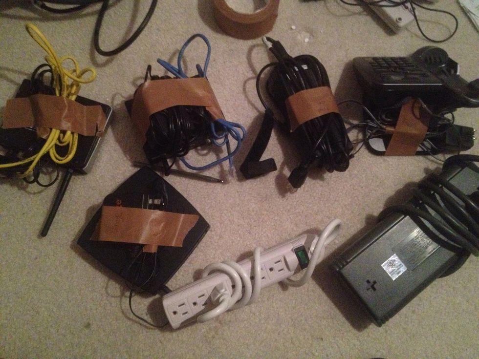 4) Find all cables pertaining to a device, and mask-tape them to the box (box in picture is labeled "wireless router") Do this to all devices