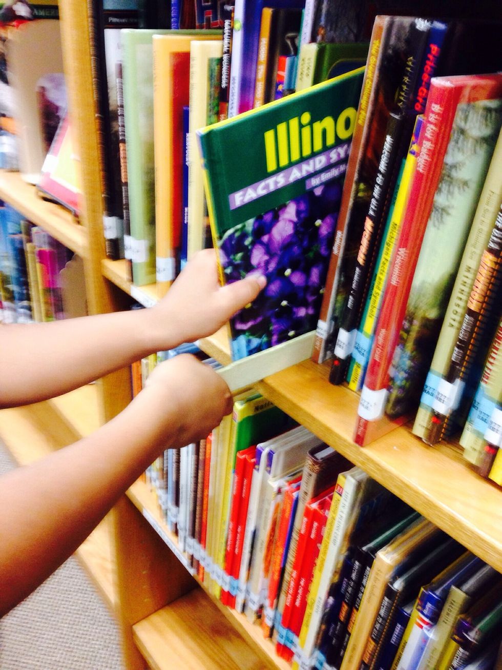 4. If you are browsing the shelves and you see a book that looks good, slide your shelf marker next to that book and pull the book out. Look through the book to make sure that it is a good fit book.