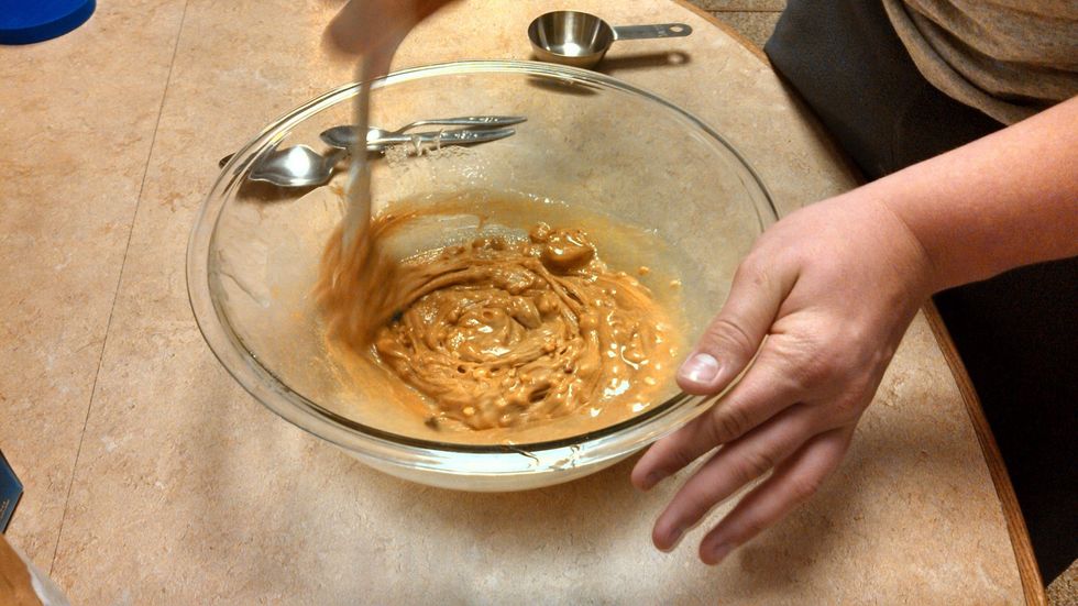 4. Next, stir the peanut butter in well. Make sure it is melting in with the sugar/syrup mixture. (If not melting or merging easily, put in microwave for about 15 seconds.)