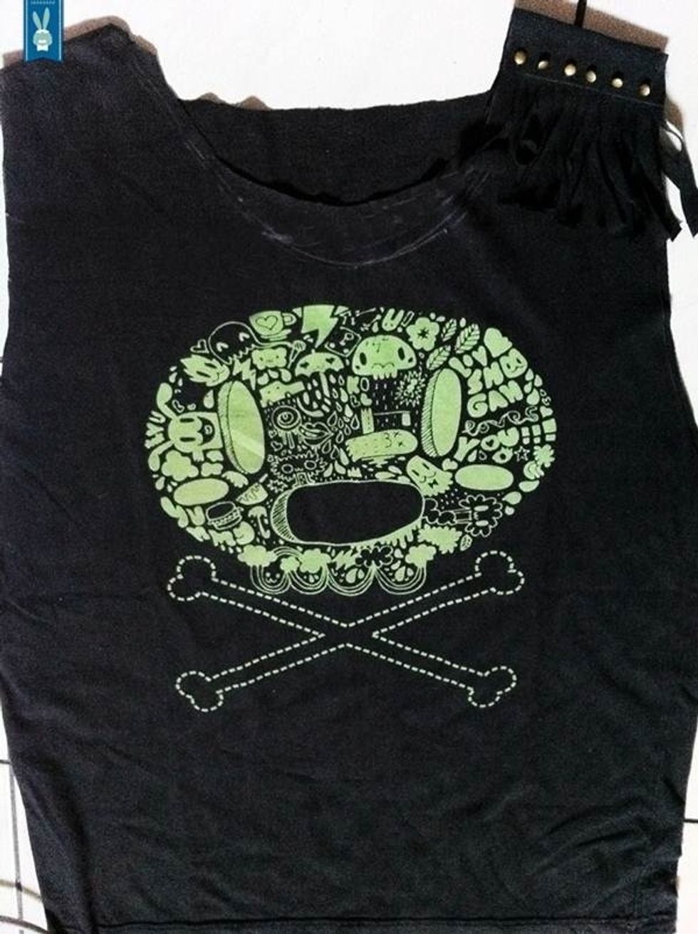 4. Now put both sleeves onto tee\u2019s shoulder. Sew a little, then hammer your studs right above the fringe. It should be easy, just remember to insert some scrap fabric between your front tee\u2019s and back