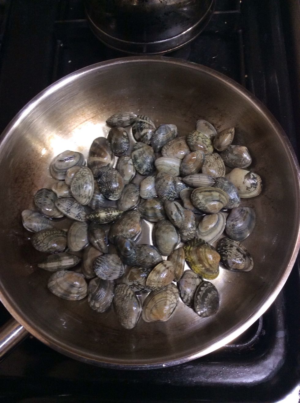 4. picking out fried garlic slices and putting clams on the pan