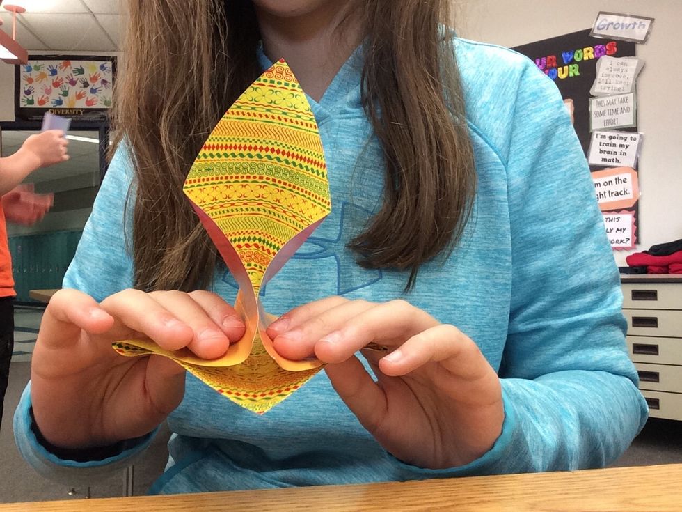 4. Take two opposite corners and fold them onto the bottom corner. (It's kind of complicated)