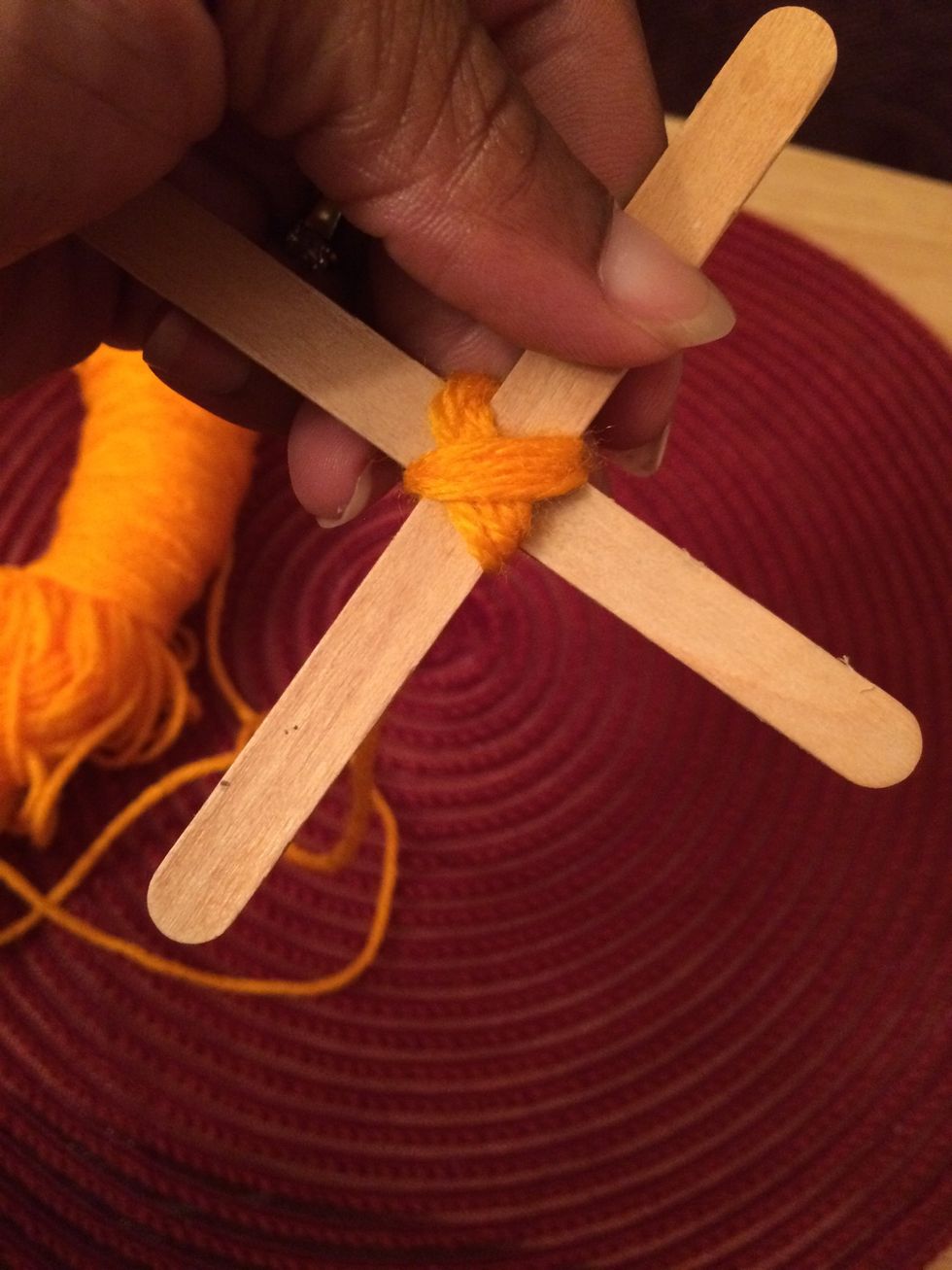 5. Next wrap the yarn around the sticks going in the opposite direction. It will make an 'x'.