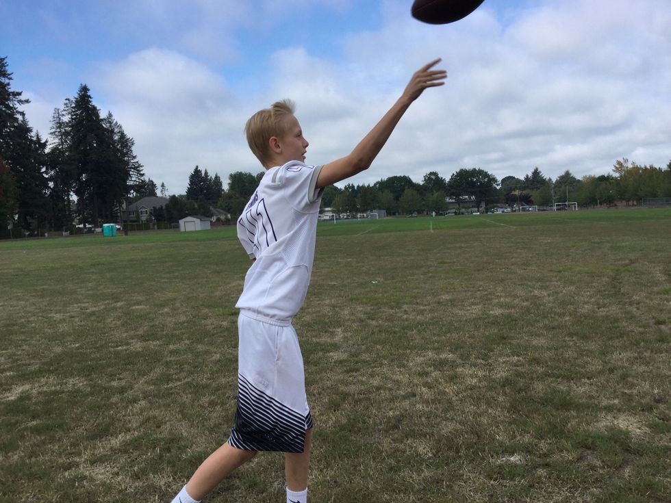 7. Release the football from your dominant hand as your hand passes your ear.