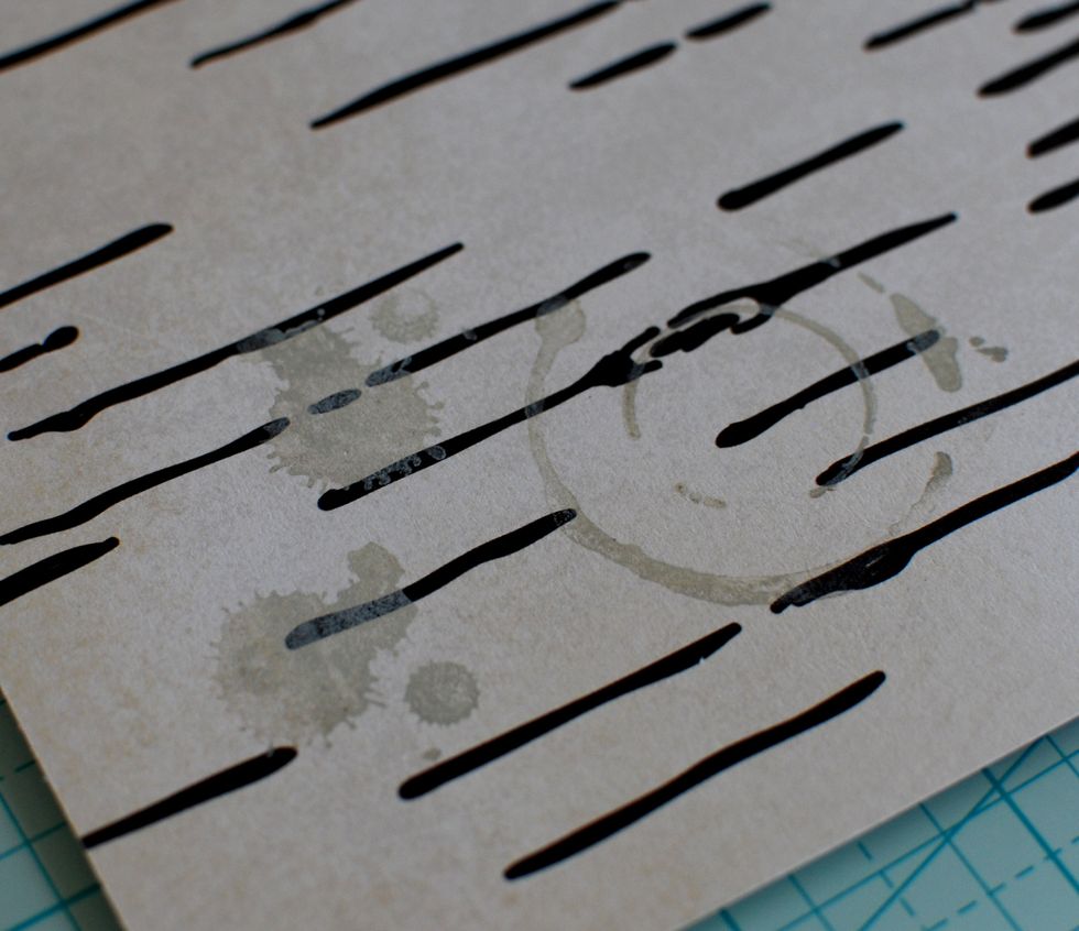 7.\tGrab your grey Ink and the Coffee Stain stamps. Place a few of the stamps around the page.