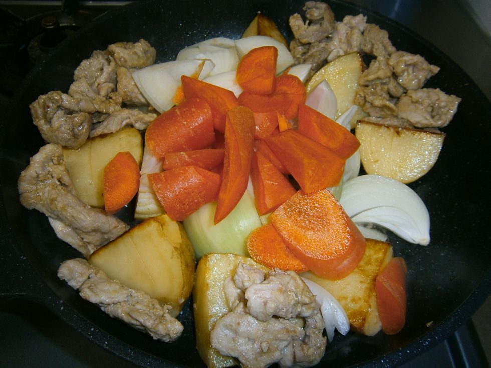 7.\tTurn the potatoes over so that the outer peel is in contact with the oil. Place the browned meat on top of the potatoes. Add the onions, carrots, and celery stalks.