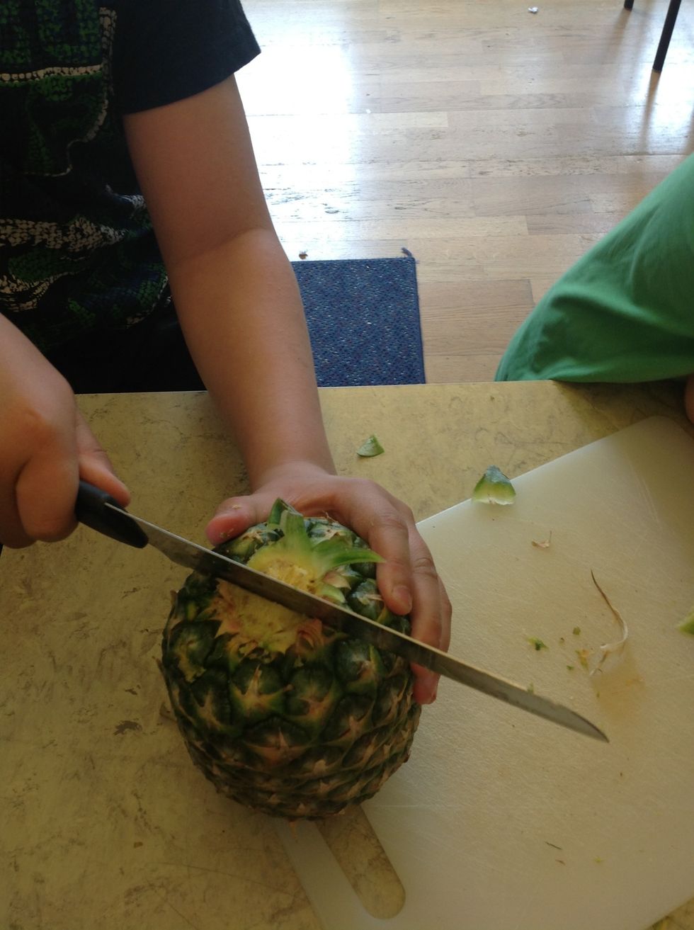 8. Cut the pineapple into two halves.