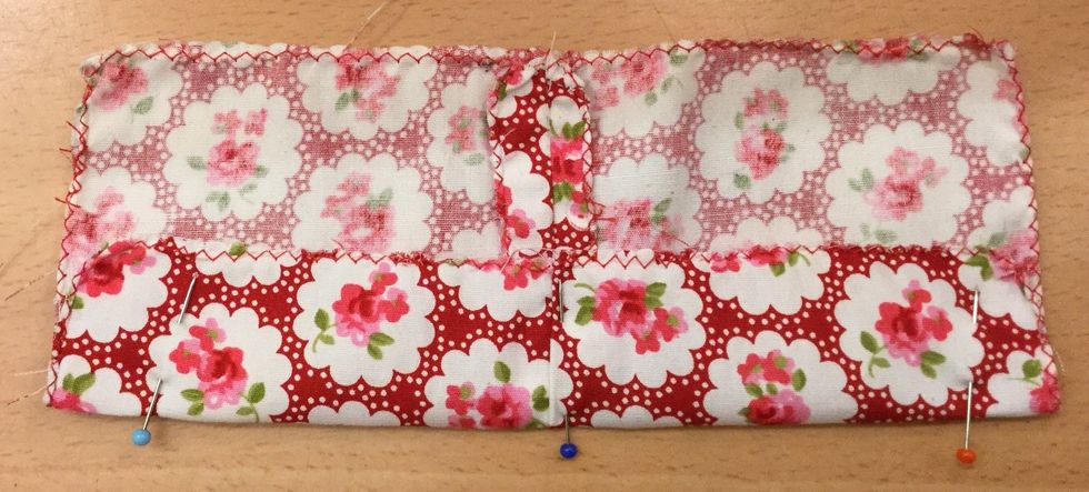 8. Vik en 3 cm bred f\u00e5ll mot avigsidan utmed l\u00e5ngsidan. Tv\u00e4rn\u00e5la fast f\u00e5llen s\u00e5 den h\u00e5ller sig p\u00e5 plats n\u00e4r du ska sy