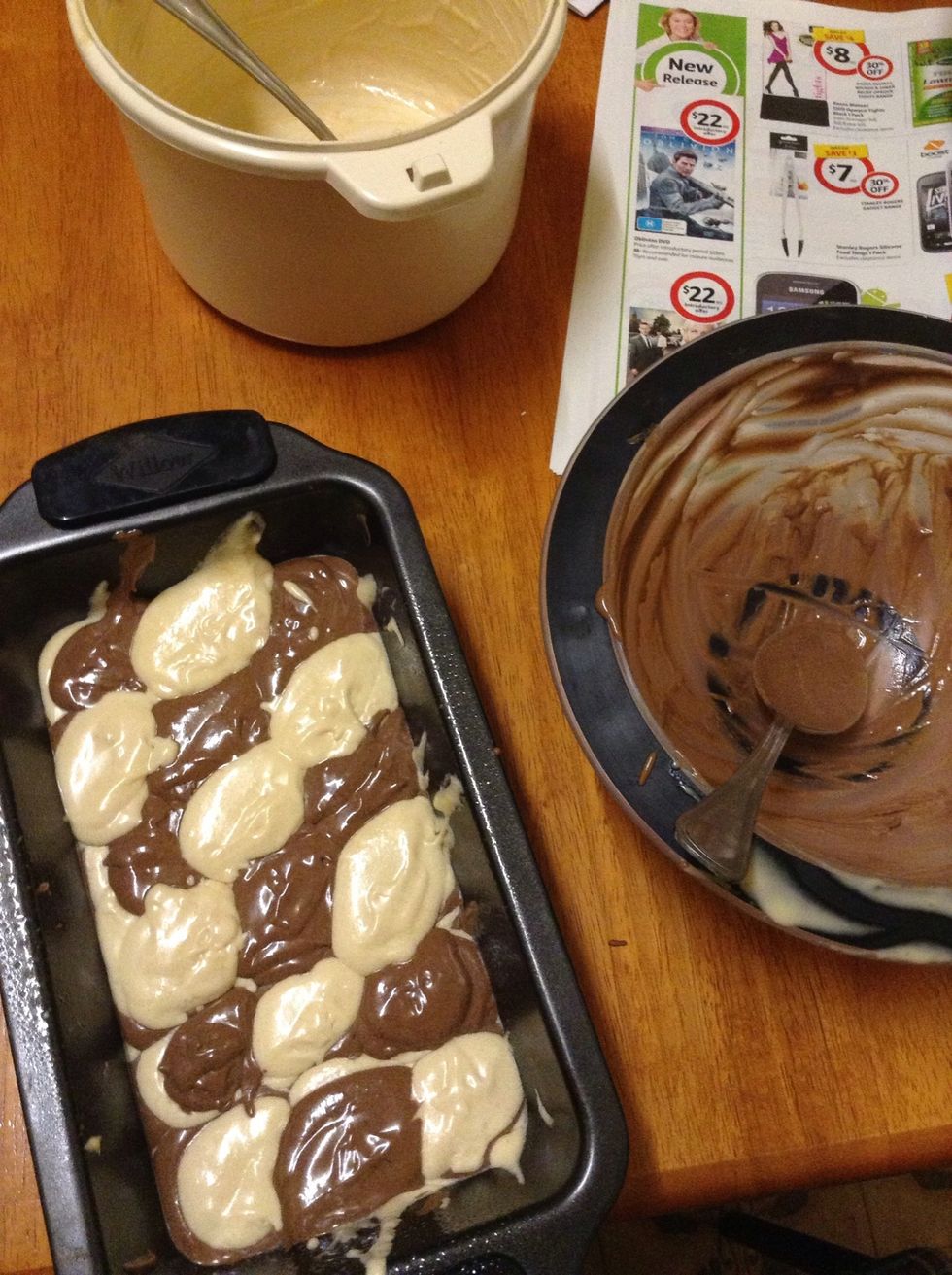 9.) Once you have your chocolate and vanilla mixes, take out a long, oblong shaped pan, and grease it. Once greased, create a checkered sort of pattern with the two mixtures - layering will be needed