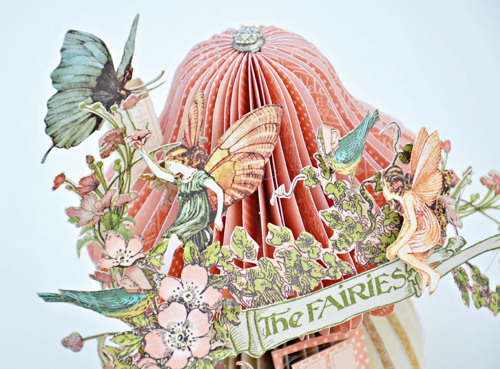 A butterfly to the top of the chimney and I have insert a Graphic 45 Brad to the top of the roof.