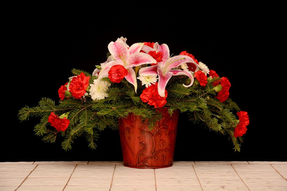 A few red miniature carnations and white pompons help to fill in the design and give greater visual impact\u2026.
