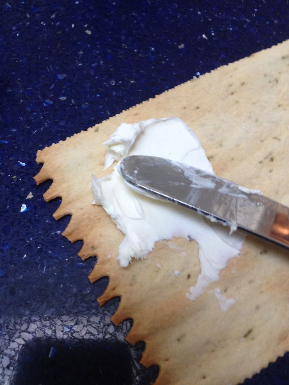A little bit at a time, spread the cream cheese carefully onto your croccantini. Don't press too hard or it will crack!