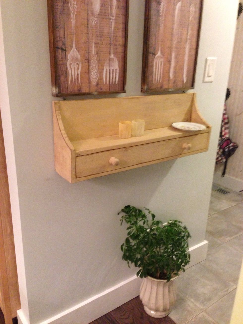 A lovely foliage plant in a hallway can make anyone feel blooming green! A flower patterned dish plate on the shelf to keep keys handy for when you want to run outside fast to have fun in the sun!