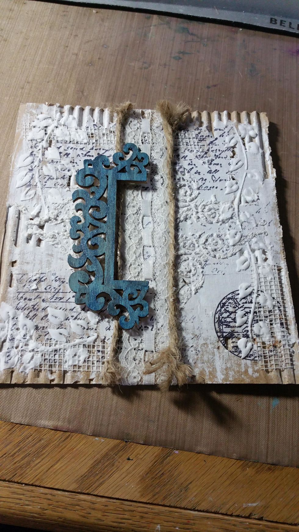 A part of a chipboard frame was painted with Art Anthology gemstones in Blue Topaz and Metal Effects in Gold. I adhered it to one side. At this step the ends of the jute were frayed.