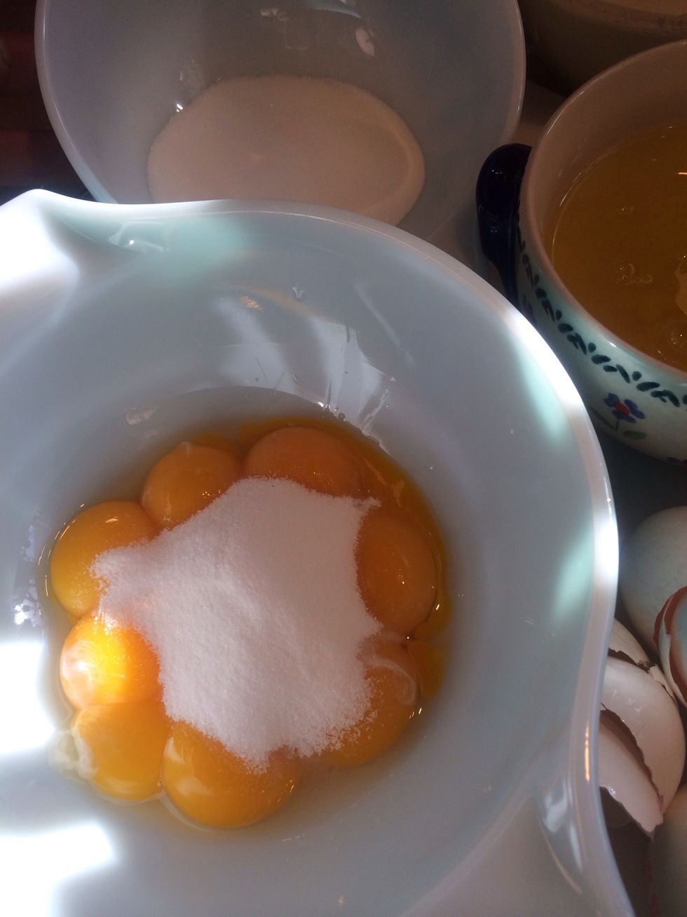 Add 1/2 of the sugar to the egg yolks.