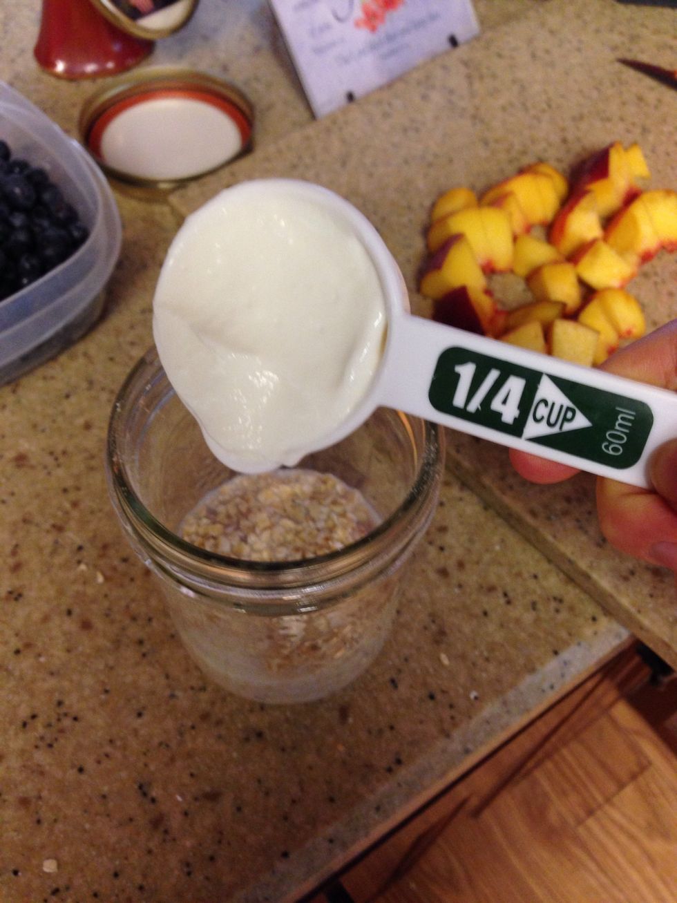 Add 1/4 cup of vanilla Greek yogurt to mason jar. (Optional)