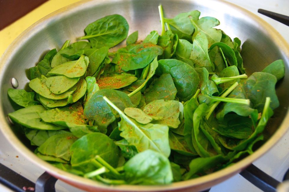 Add 1 TBSP of olive oil to a large saut\u00e9 pan and  turn your stove on to medium heat.  Add the spinach and a pinch or two of Chipotle Seasoning. You want to wilt the spinach down and remove the water.