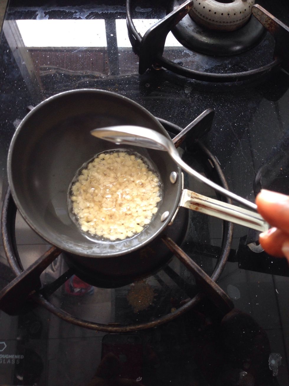 Add 1 tbsp urad dal (split Black lentil) roast until turns golden brown then add 1 tsp mustard seeds let it crackle and den add 2 slit green chillies.. Turn the heat off