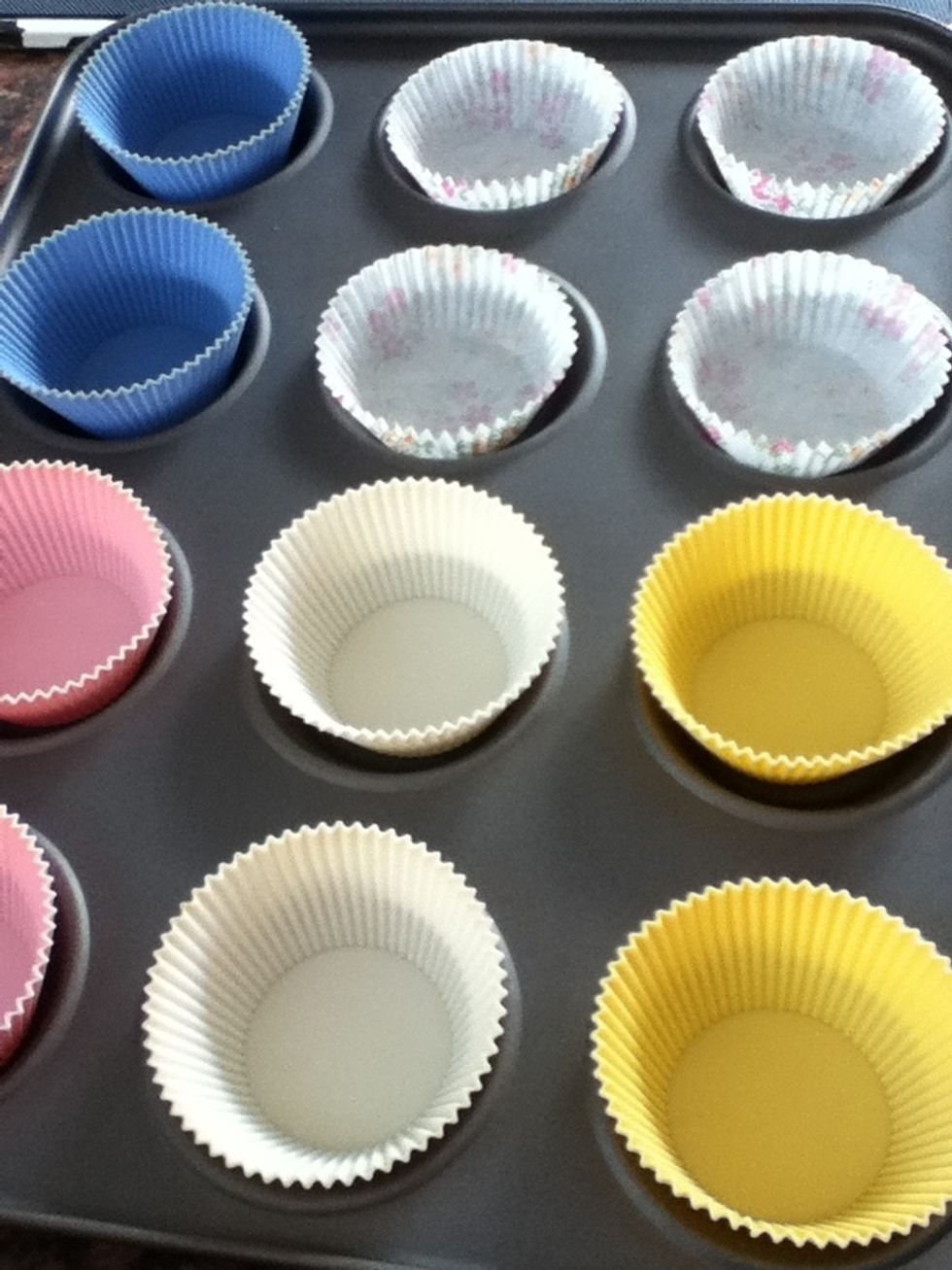 Add 12 cupcake cases to a tray.