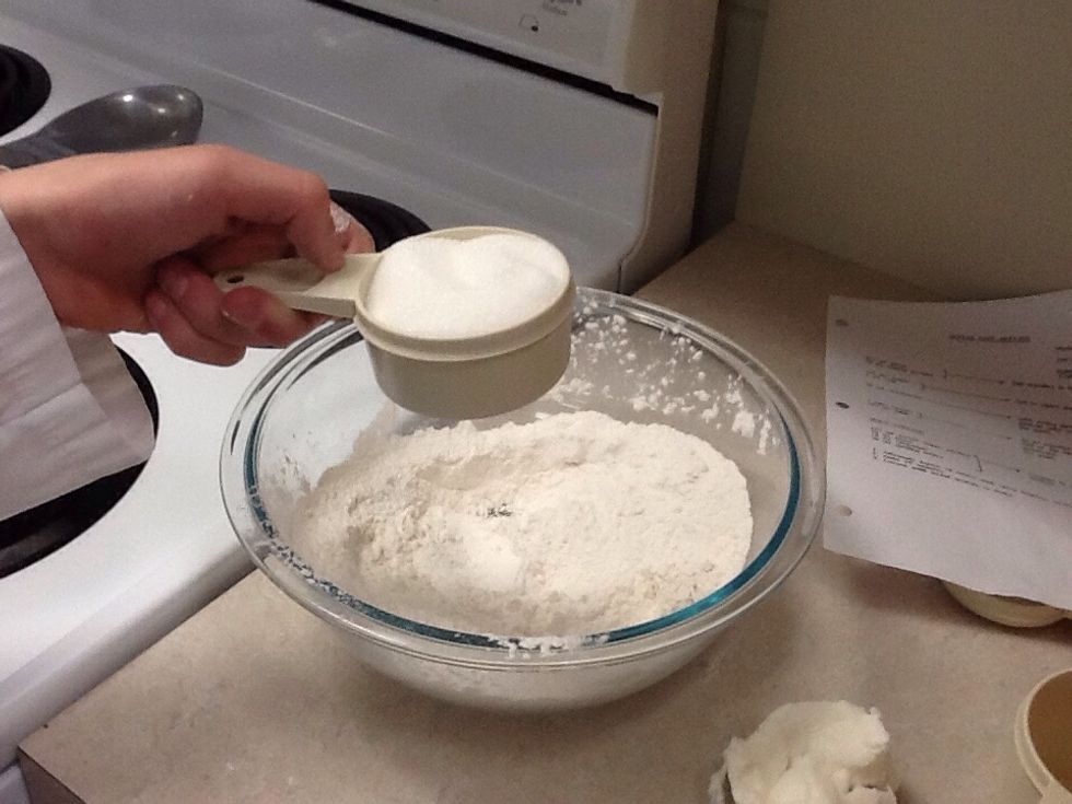 Add 125 mL of sugar to the bowl of flour