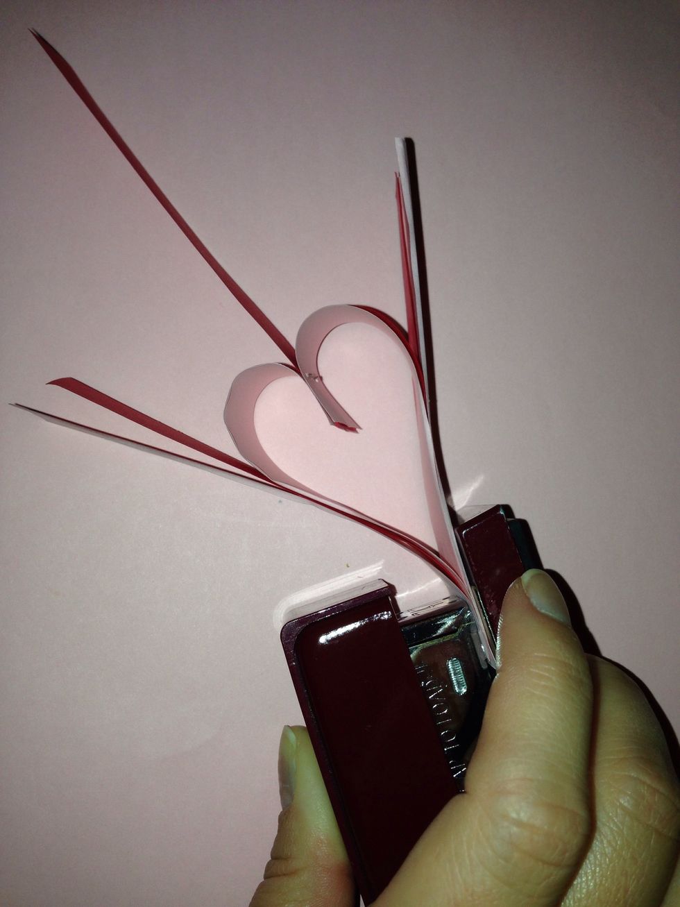 Add 2 additional strips to the bottom of the heart. Make sure the paper is even with the bottom of the first heart and the paper is pointing up and out. Staple.