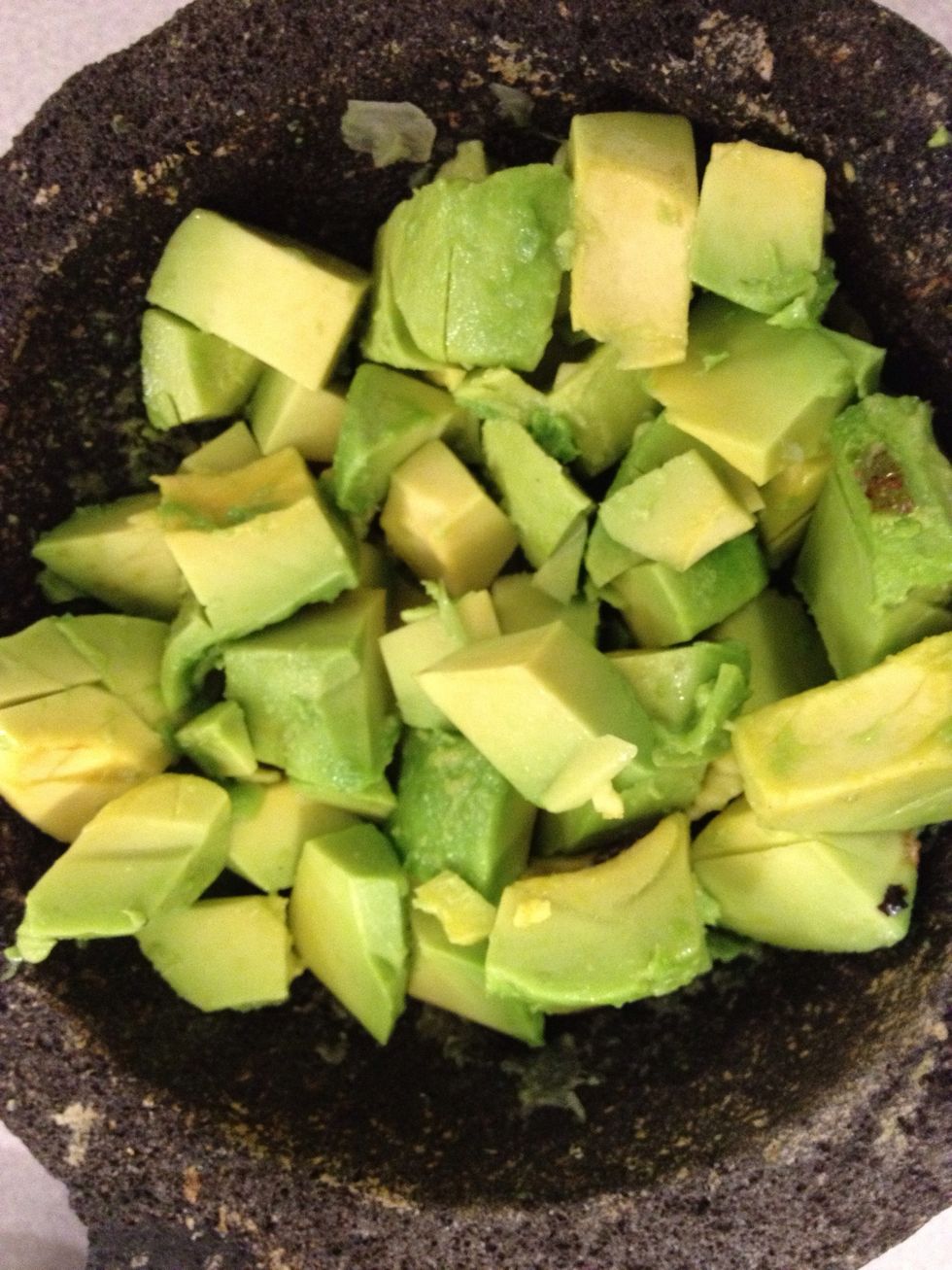 Add 2 chopped avocados to the molcajete.