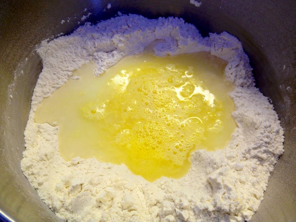 Add 2 eggs, warm water and warm milk. Make sure they are lukewarm so that the yeast becomes active.