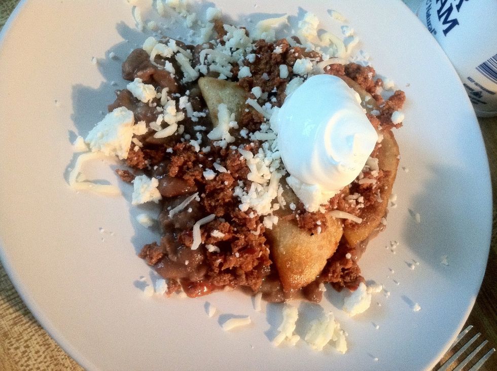 Add 2 empanadas.some more beans and lettuce, tomato, cheese and sour cream. Enjoy