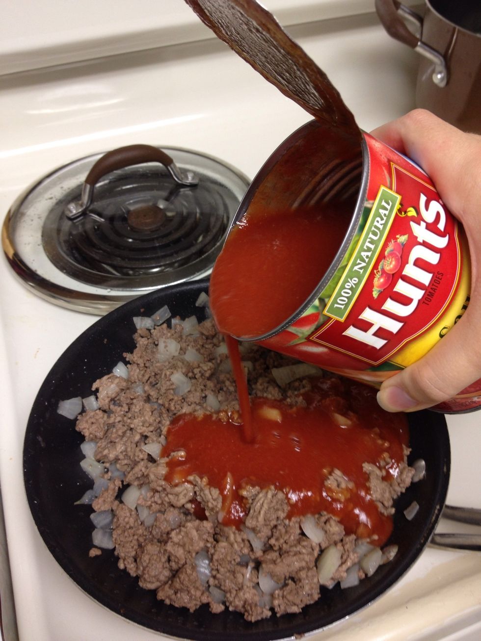 Add 26 oz of tomato sauce to cooked ground beef.