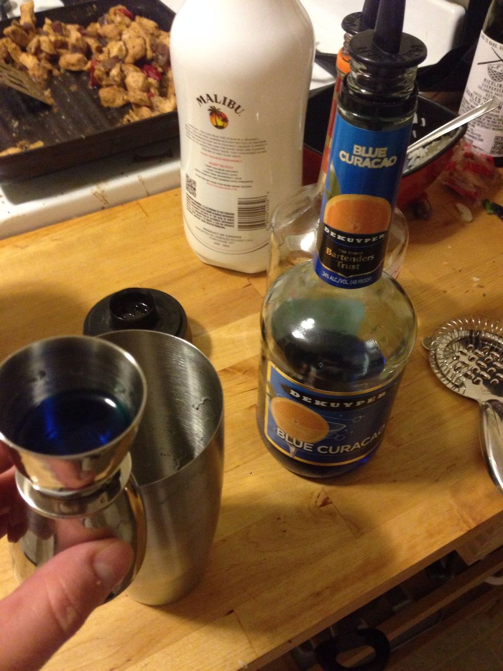 Add 3/4 oz of blue cura\u00e7ao to a mixing glass.