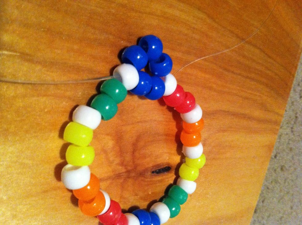 Add 3 blue beads and thread it through the next white bead. Do this all around until your back at the beginning.