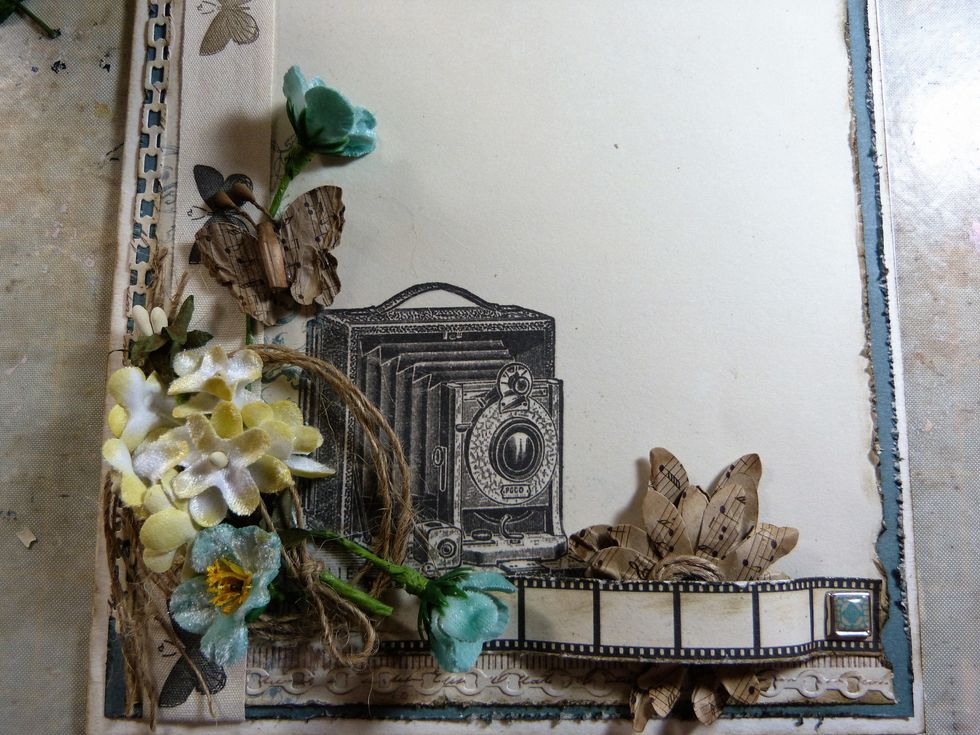 Add 3 blue Petaloo flowers, keep 2 with long stems and add 1 along the bottom and 1 up the side. Add a Kraft Petaloo Butterfly to the top stem.