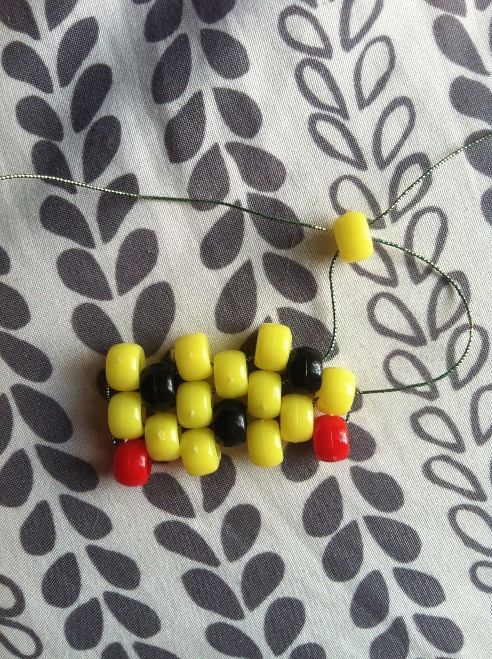Add 3 more yellow beads and once you get to the last bead grab your other string and thread through the bead in an opposite way.