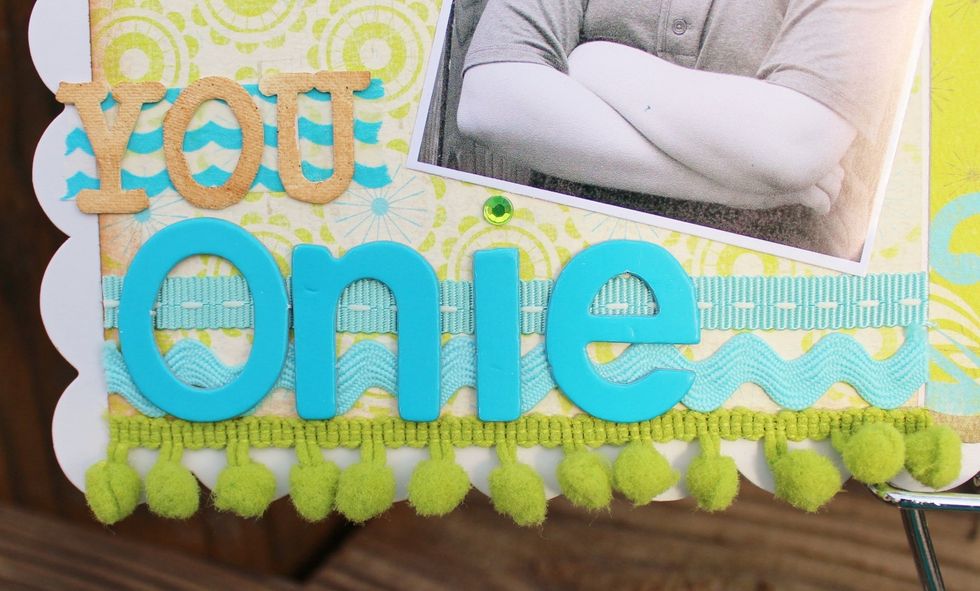 add 3 strips of ribbons and trims along bottom left printed paper. add a strip of washi tape above ribbons as base for wording.