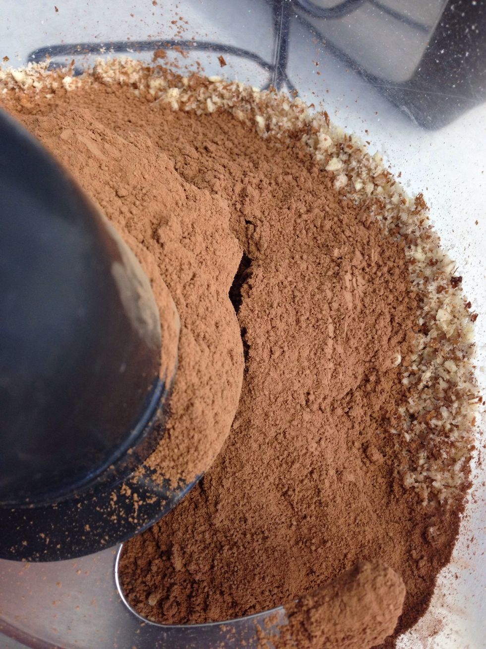 Add 3 tablespoons of cacao powder to the almonds, along with a pinch of sea salt.